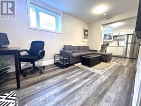 Toronto (East End-Danforth) apartment for rent - A well-lit living room with a grey sofa and a black chair.
