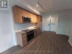 Milton (Cb Cobban) condo for rent - A kitchen with wooden cabinets and a microwave above the stove.