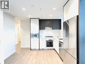 Coquitlam apartment for rent - A modern kitchen with white appliances and wooden floors.