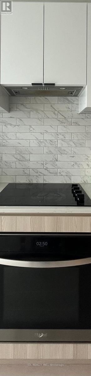 Toronto (Church-Yonge Corridor) condo for rent - A modern kitchen with a black oven and white cabinets.