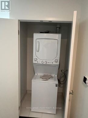 Toronto (Humber Heights) condo for rent - A white compact washing machine is installed in a small bathroom.