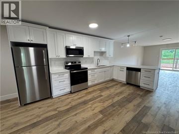 Hampton apartment for rent - A kitchen with white cabinets and a wooden floor.