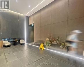 Toronto (Moss Park) condo for rent - A yellow caution sign is on the floor of a modern lobby.