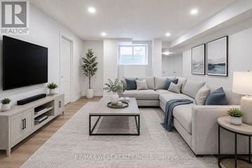 Bradford West Gwillimbury (Bradford) apartment for rent - A modern living room with a grey sofa, a glass coffee table, and a television on a cabinet.