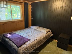 Oro-Medonte apartment for rent - A bedroom with a bed, a window, and a wooden headboard.