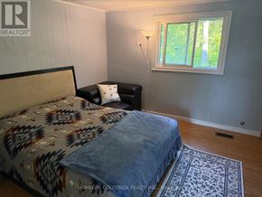 Oro-Medonte apartment for rent - A bedroom with a bed, a chair, and a window.