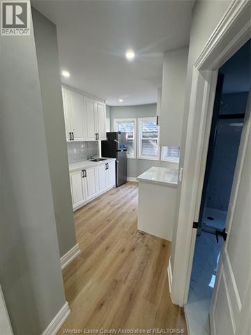 Windsor apartment for rent - A kitchen with white cabinets and a black fridge.