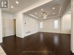 Vaughan (Kleinburg) apartment for rent - A spacious room with wooden floors and white walls.