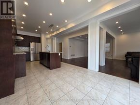 Vaughan (Kleinburg) apartment for rent - A spacious living room with a kitchen area in the background.