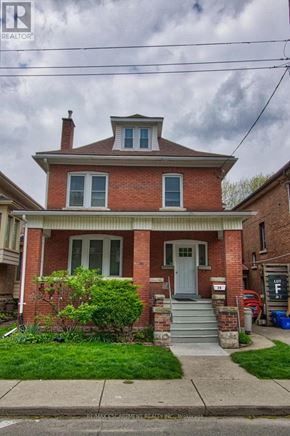 Hamilton (Stipley) apartment for rent - A brick house with a green bush in front.