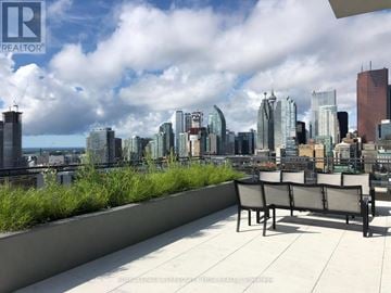 Toronto (Moss Park) condo for rent - A cityscape with a bench in the foreground.