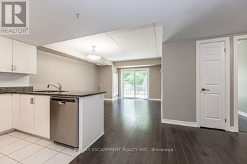 Kitchener condo for rent - A kitchen with white cabinets and a black granite countertop.