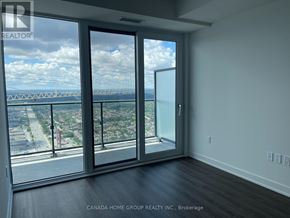 Mississauga (City Centre) condo for rent - A room with a view of a bridge and cityscape through large windows.
