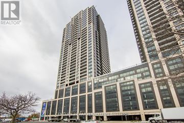 Toronto (High Park-Swansea) condo for rent - A tall building with a glass facade stands next to a shorter building with a beige facade.