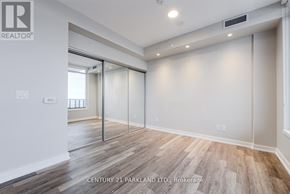Toronto (High Park-Swansea) condo for rent - A spacious room with wooden flooring and a glass door.