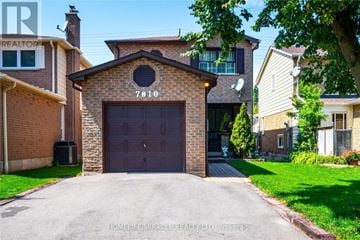 Mississauga (Meadowvale) apartment for rent - A house with a brick facade and a large garage door.