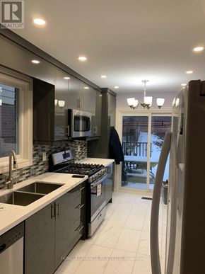 Mississauga (Meadowvale) apartment for rent - A modern kitchen with a large island and a view of the backyard.