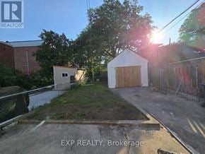 Toronto (Danforth) apartment for rent - A real estate sign is displayed in the upper left corner of a photo showing a property with a shed and a fenced area.
