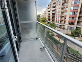 Toronto (Bayview Village) condo for rent - A balcony with a glass door and a railing overlooking a residential area.