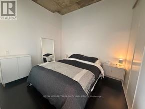Toronto (Waterfront Communities) condo for rent - A bedroom with a bed, nightstand, and wardrobe.