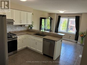 Guelph (Grange Road) apartment for rent - A kitchen with white cabinets and a tiled floor.