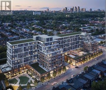 Toronto (Dovercourt-Wallace Emerson-Junction) condo for rent - An aerial view of a modern multi-story building with a green roof and a courtyard in the foreground.