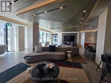 Toronto (Dovercourt-Wallace Emerson-Junction) condo for rent - A modern living room with a curved sofa and a coffee table in the center.