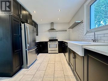 Hamilton (Inch Park) apartment for rent - A kitchen with black cabinets and a white tiled backsplash.