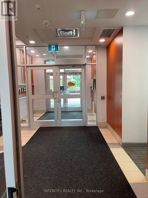 Hamilton (Ainslie Wood) condo for rent - A hallway with a black carpet and a glass door with a sign above it.
