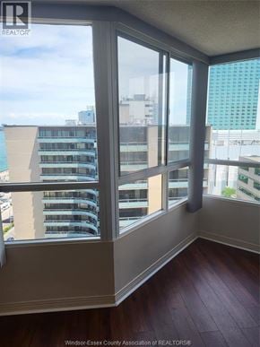 Windsor condo for rent - A room with a view of a cityscape through large windows.