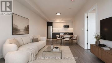 Toronto (Forest Hill North) condo for rent - A modern living room with a white sofa and a glass coffee table.