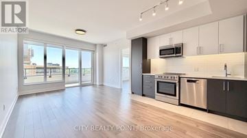 Toronto (Forest Hill North) condo for rent - A modern kitchen with stainless steel appliances and wooden flooring.