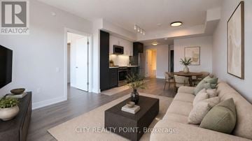 Toronto (Forest Hill North) condo for rent - A modern living room with a large couch and a coffee table.
