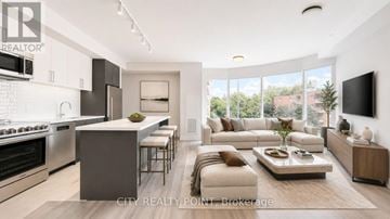 Toronto (Forest Hill North) condo for rent - A modern kitchen with a breakfast bar and a living room with a couch and a coffee table.