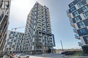 Oakville (Jm Joshua Meadows) condo for rent - A modern building with a crane in the background.