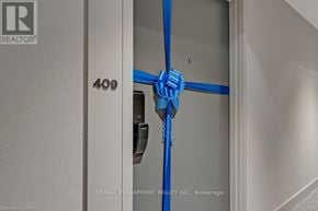 Oakville (Jm Joshua Meadows) condo for rent - A blue tape is taped across a door with the number 409 on it.
