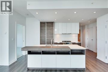 Burnaby apartment for rent - A modern kitchen with white cabinets and a wooden backsplash.