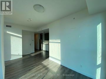 Kitchener condo for rent - A large, empty room with wooden floors and white walls.