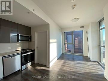 Kitchener condo for rent - A kitchen with white cabinets and a black stove top oven.