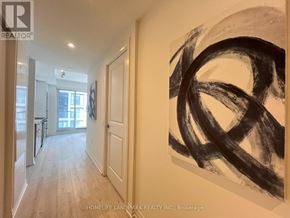 Toronto (Moss Park) condo for rent - A hallway with a large painting on the wall and a door on the left.