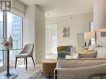 Toronto (Moss Park) condo for rent - A well-lit living room with a glass table and a yellow chair.