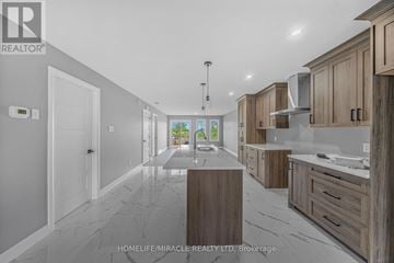 Cornwall apartment for rent - A modern kitchen with wooden cabinets and a marble floor.