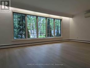 Toronto (Bayview Village) apartment for rent - A room with a large window and wooden flooring.