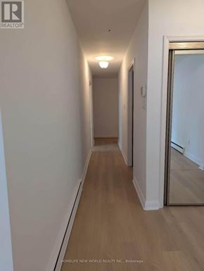 Toronto (Bayview Village) apartment for rent - A long hallway with wood floors and white walls.