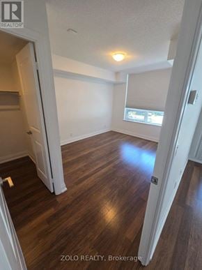Richmond Hill (Doncrest) condo for rent - A room with wooden flooring and white walls, with a window and a door visible.