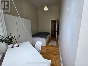 Toronto (Kensington-Chinatown) multi-family for rent - A bedroom with a bed, desk, and chair.