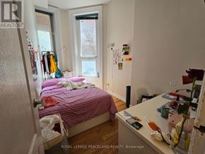 Toronto (Kensington-Chinatown) multi-family for rent - A bedroom with a bed, desk, and window.