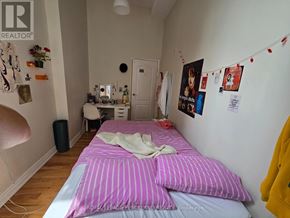 Toronto (Kensington-Chinatown) multi-family for rent - A bedroom with a bed, a dresser, and a mirror.