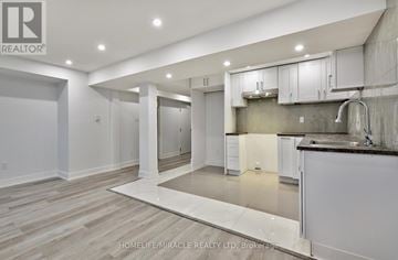 Clarington (Bowmanville) apartment for rent - A modern kitchen with white cabinets and a black countertop.