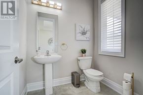 Oakville (Jm Joshua Meadows) apartment for rent - A white bathroom with a toilet, sink, and mirror.